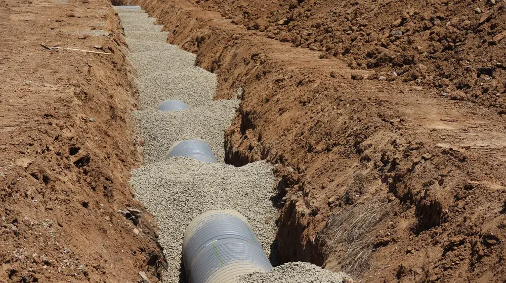 Perforated septic distribution pipe laid in a gravel drainfield trench