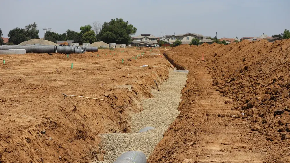 Open septic drainfield trench with a gravel bed and distribution pipe